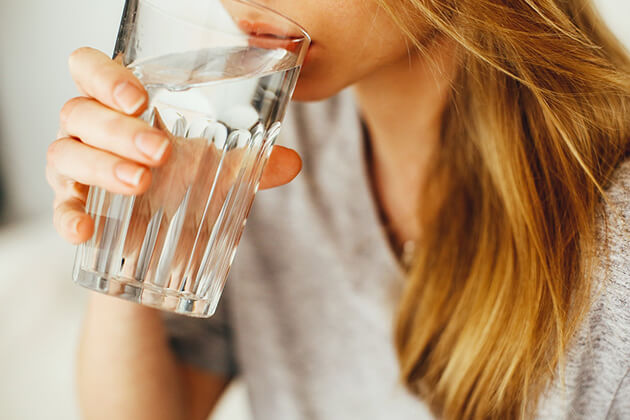 מרכך מים ביתי אישה שותה כוס מים